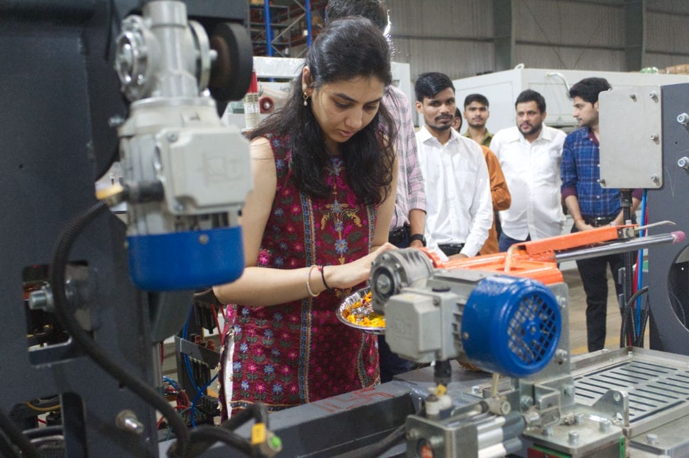Woman working with industrial machinery in factory setting.