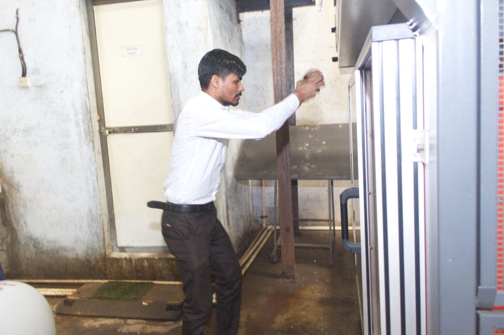 Person cleaning industrial equipment in kitchen