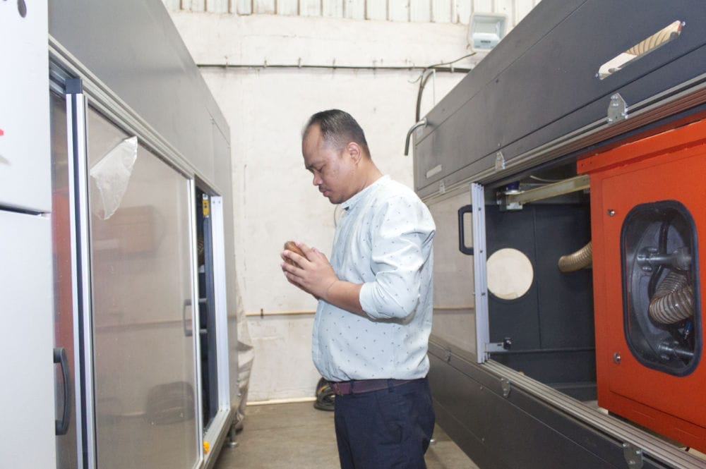 Man inspecting industrial machinery in factory setting.
