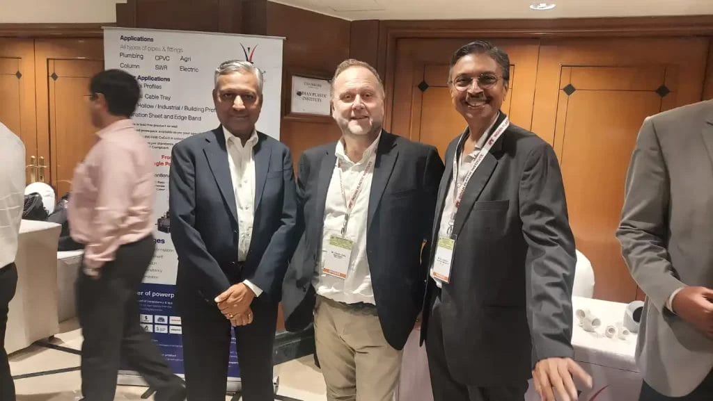 Three men in suits at industry conference