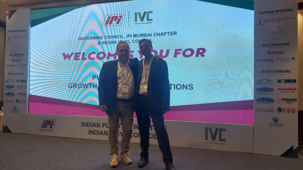 Two people at Indian Plastics Institute event.