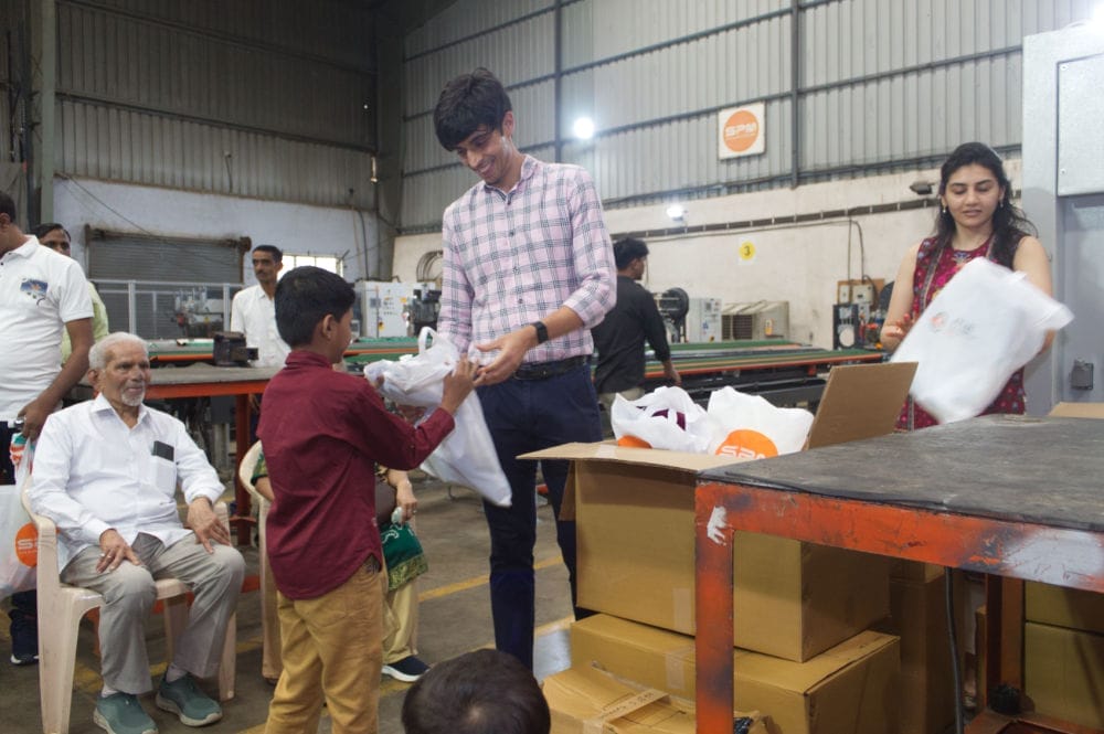People distributing packages in an industrial setting.