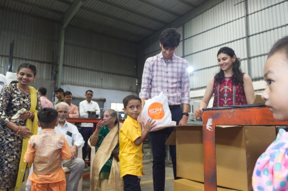 Volunteers distributing supplies to children in warehouse.
