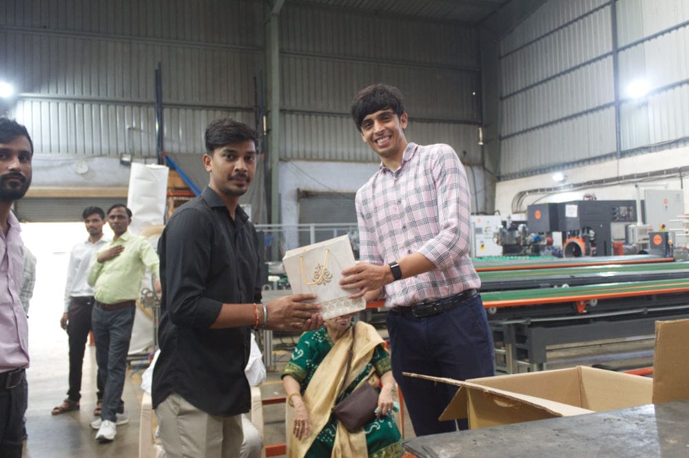 People exchanging gifts in industrial warehouse setting.