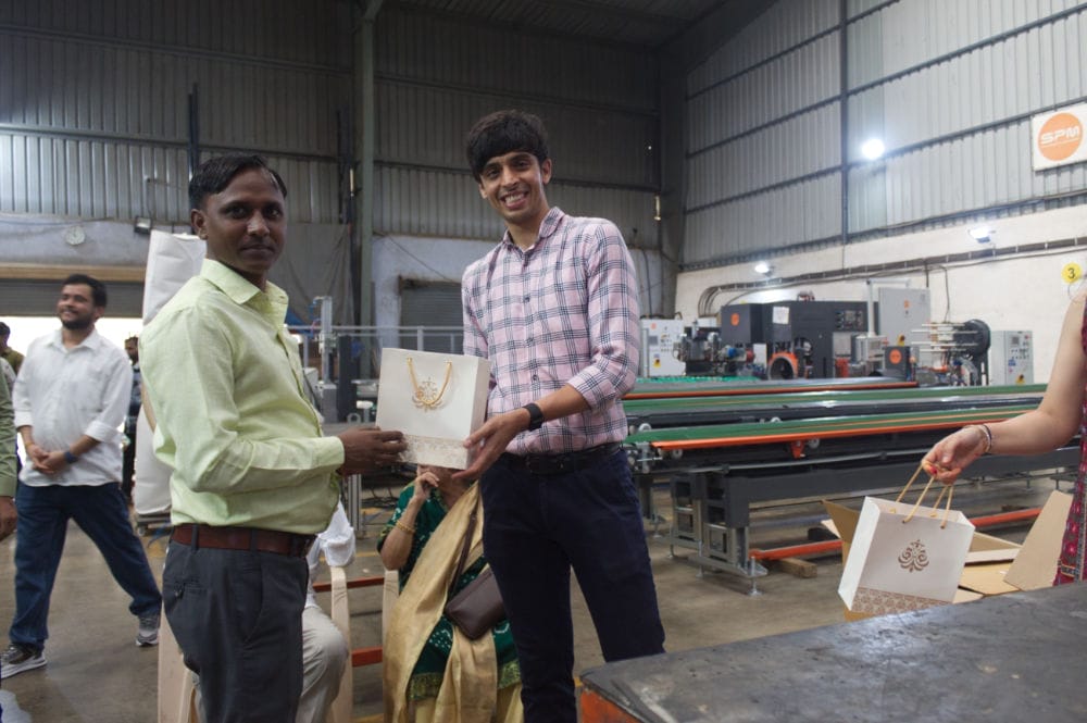 Two men exchanging a gift in a factory.