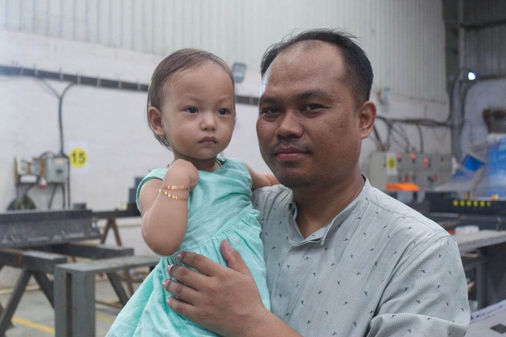 Man holding child in factory setting
