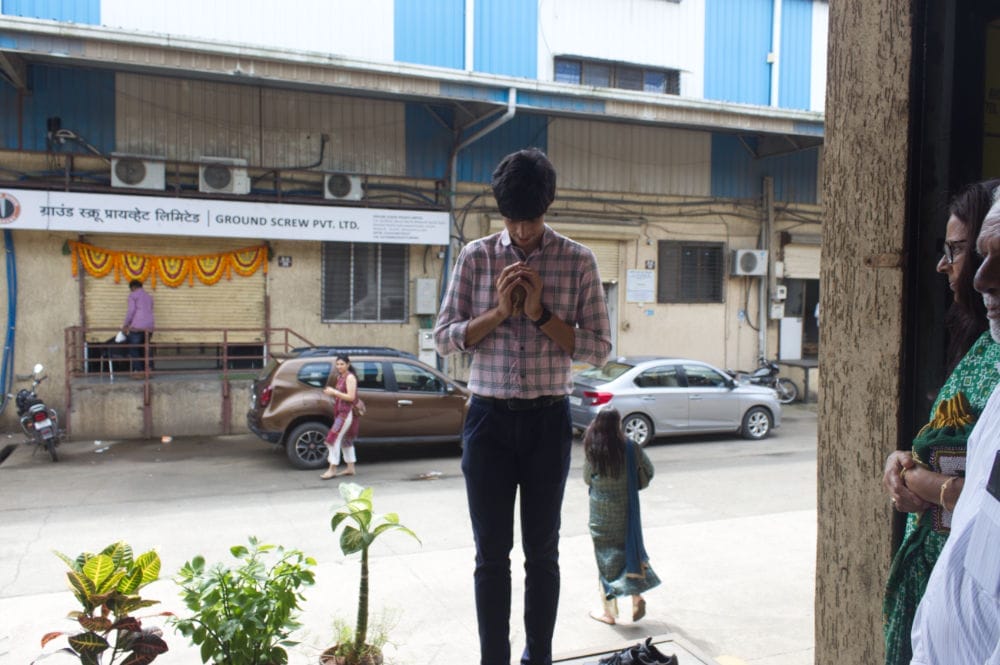 Person folding hands in front of a garage.