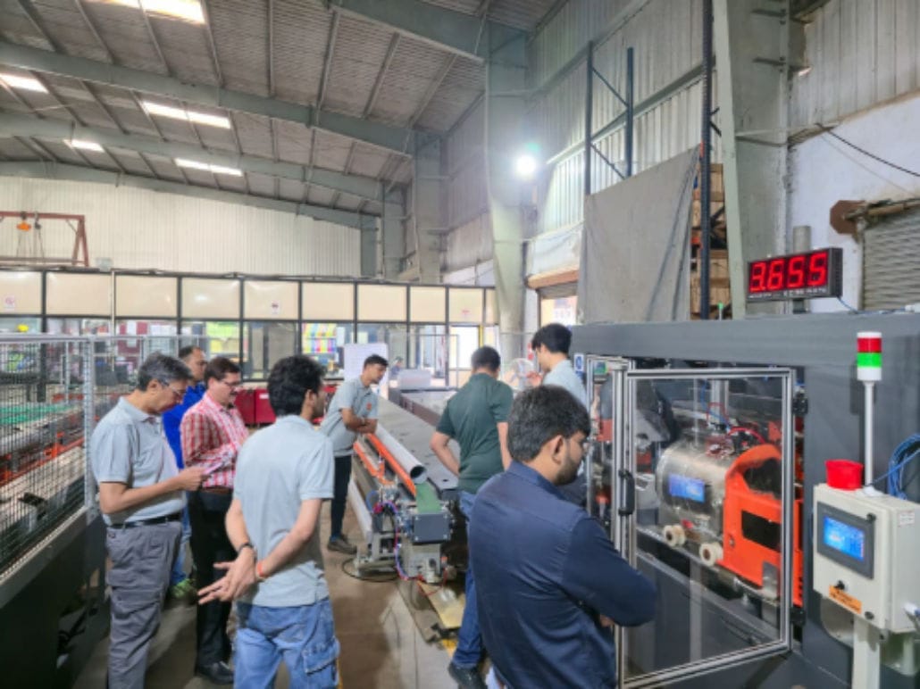People observing factory machinery in operation